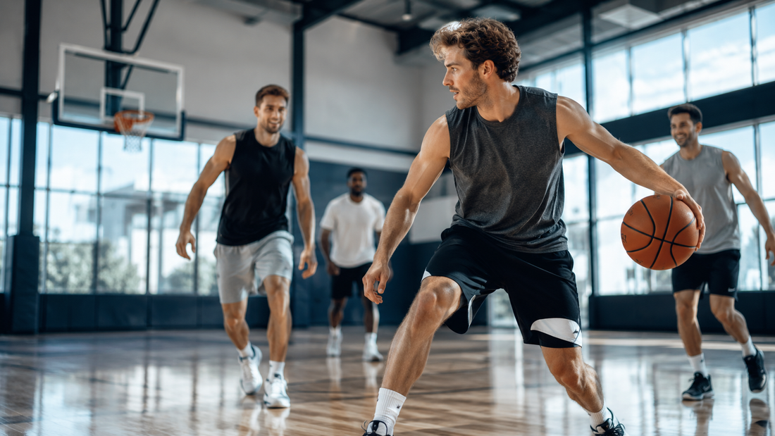 Man playing basketball in a gym with teammates during an active game