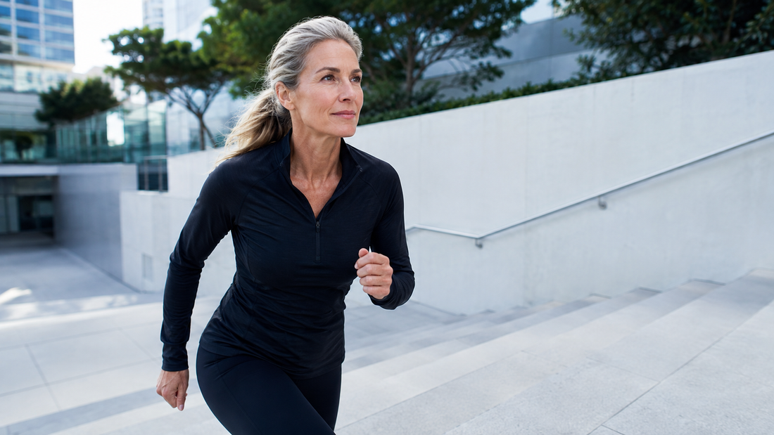 Active woman in her 50s climbing outdoor steps, representing cellular energy, longevity, and healthy aging